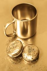 Golden cookies on a gold background. Nearby is a golden cup.
