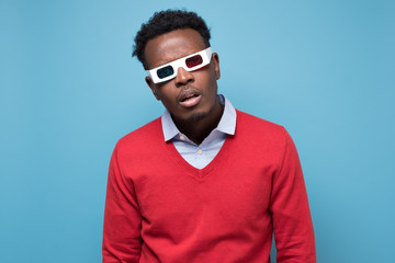 African young man in 3-d glasses watching thiller being stunned.