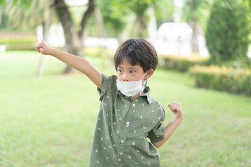 a strong boy is play in the garden with mask.