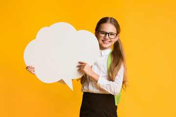 Schoolgirl Holding Speech Bubble Smiling To Camera, Studio Shot, Mockup