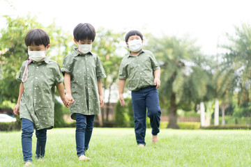 Obraz premium 3 brothers are walking and playing in the garden in the evening..