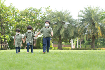 3 brothers are walking and playing in the garden in the evening..