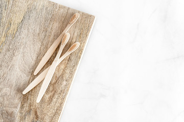 Composition with biodegradable bamboo toothbrushes on marble background. Sustainable, zero waste, plastic free, lifestyle concept. Eco-friendly oral hygiene accessories.Flat lay, top view, copy space.