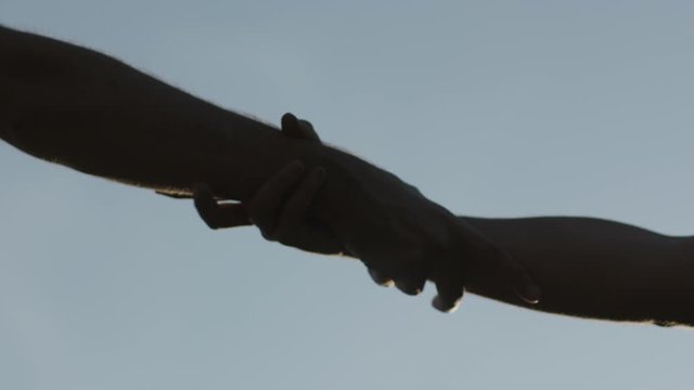 hands are held tightly to help each other up