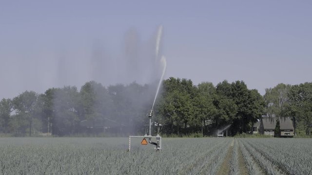 Big agriculture water gun in a field on a sunny and hot summer day