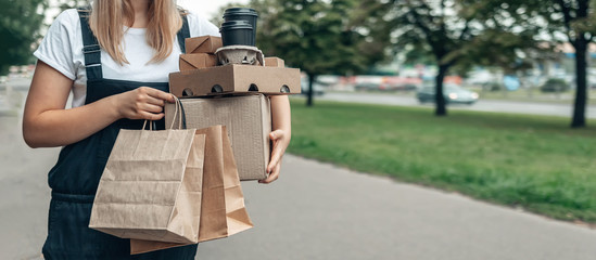 Contactless delivery. Girl Courier with food takeaway zero waste paper packaging delivers...