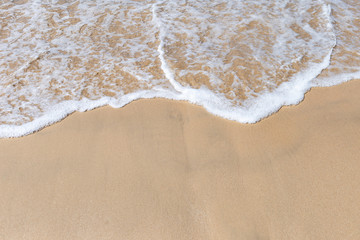Fototapeta na wymiar White wave on a fine sand beach, nature background, summer outdoor daylight