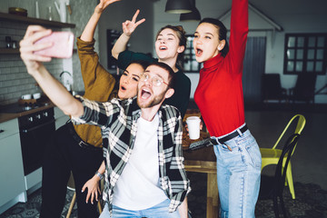 Satisfied fellows taking selfie in apartment