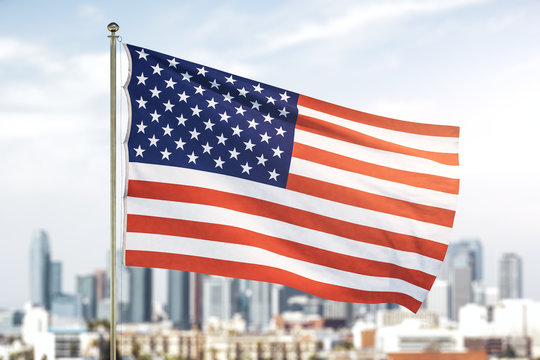 USA flag on blurry skyline background at daytime