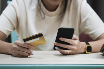 Online payment and shopping, Woman's hands holding credit card and using smartphone mobile for online shopping.