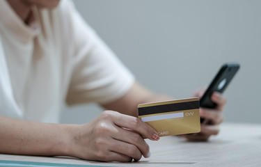 Fototapeta premium Online payment and shopping, Woman's hands holding credit card and using smartphone mobile for online shopping.