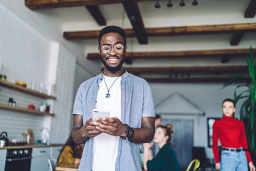 Young African American man browsing smartphone at friends house