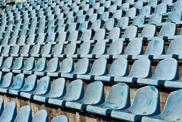 Lots of empty seats in the stadium. Texture of blue chairs. Plastic seats are arranged in a row.