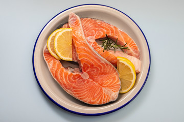 fresh raw salmon on the dish on blue background
