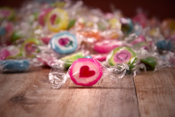 Colorful candies on a wooden background stock images. Sweets on the table. Pile of candies on a wooden background images. Candy with heart stock images