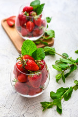 Glass with fresh ripe strawberry on light background