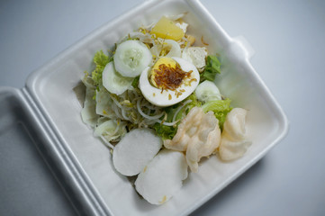 Gado-gado (Indonesian) is traditional indonesian food. rice cake, egg and vegetable with peanut sauce. Selective Focus.     