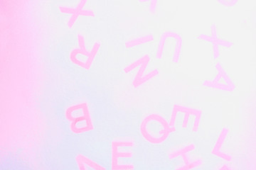Silhouettes of alphabet letters on pink background. English letters stamp. Top view. Copy space for your creative design