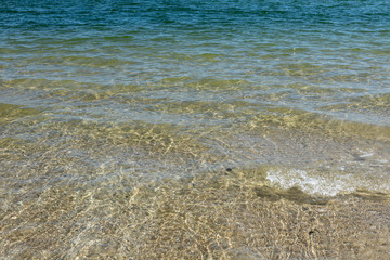 Beautiful clear blue sea. Transparent water background and texture. Summer vacation with family