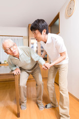 Obraz premium シニア男性の歩行介助をする介護福祉士