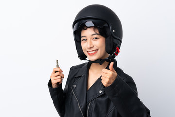 Young Asian girl with a motorcycle helmet and a key over isolated white background