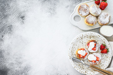 Obraz na płótnie Canvas Cottage cheese pancakes. Syrniki with fresh strawberries. Gray background. Top view. Copy space