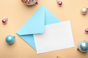 Christmas composition with blank card and envelope on color background