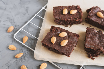 Chocolate brownie cake cut in small square pieces and served with almonds. Homemade dessert recipe