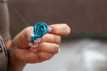 old female hands sew fabric with a needle and thread