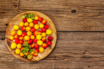 Harvest ripe cherry plum with seeds on wooden background