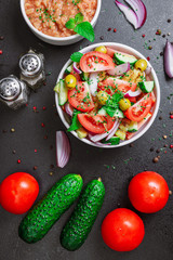 Summer salad with tomatoes, cucumbers, olives and microgreen on a top view table