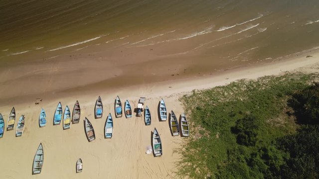 Ascending aerial of fishing boats beached on the sand in the fishing village of Icacos, Trinidad