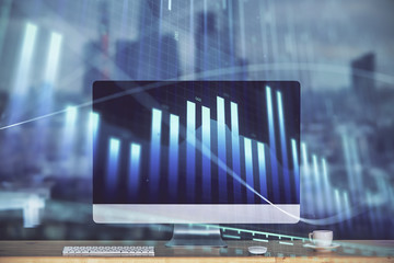 Stock market graph on background with desk and personal computer. Double exposure. Concept of financial analysis.