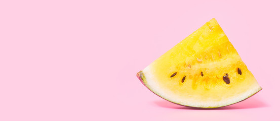 Banner ,slices of yellow watermelon on a pastel pink background, copy space