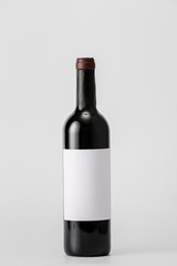 Bottle of wine with blank label on light background. Mockup for design