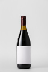 Bottle of wine with blank label on light background. Mockup for design