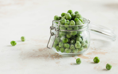 Frozen peas in a glass jar. Freezing is a safe method of increasing the shelf life of nutritious foods. Copy space