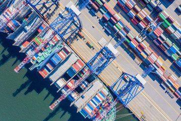 Container ship loading at port with crane, container ship carrying container import and export business logistic and transportation, Aerial top view.
