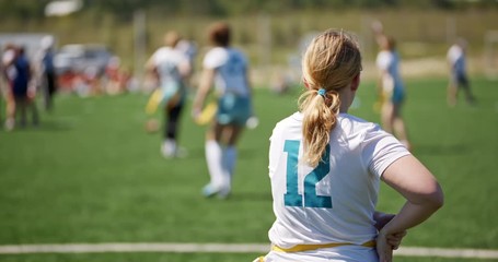 Silhouettes of young girls playing on the field in flag football. The female team preparing for the competition and setting up for the game. Concept of sport and victory. American sports - Powered by Adobe