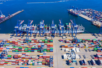 Container ship loading at port with crane, container ship carrying container import and export business logistic and transportation, Aerial top view.