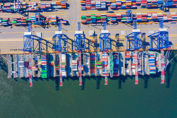 Fototapeta na wymiar Container ship loading at port with crane, container ship carrying container import and export business logistic and transportation, Aerial top view.