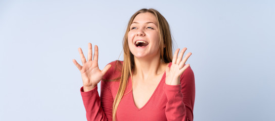 Fototapeta na wymiar Teenager Ukrainian girl isolated on blue background with surprise facial expression