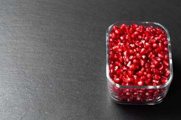 Peeled pomegranate in Minsk on a dark background.