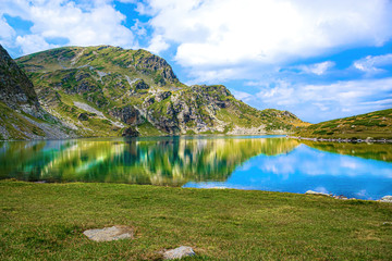 National park  Seven Rila Lakes in Bulgarian mountains.  Hiking in Bulgaria, Europe. Blue lake, purple flowers and high mount peak in summer.  Amazing scenery wallpaper for tourism. Beautiful nature.

