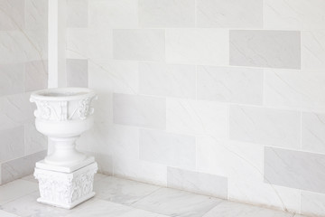 The white stylish interior with Old vintage marble pot on marble background.
