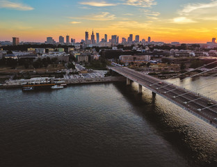 Capital cityscape and a suspension bridge over a large river. Drone, aerial view