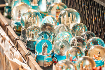 Souvenirs and gifts.A table in a street market with glittering glass balls with figures. Close up