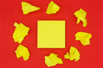 Stack of sticky notes in the middle and crumpled notes around. Yellow blank stickers on red background.