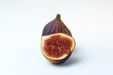 One whole and one half figs on a white background