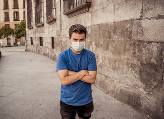 Portrait of young sad man with protective surgical face mask in public spaces in the new normal